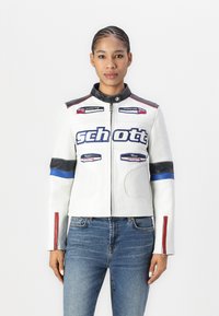Casaco de motociclista em couro branco com detalhes em azul e vermelho e fecho de correr. Apresenta logótipos e um design perfurado para ventilação.
