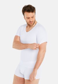 White, short-sleeve V-neck undershirt, fitted design, smooth texture, paired with matching boxer briefs, showcasing a clean, minimalist style.