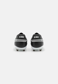 Scarpe da calcio nere con dettagli bianchi. Presentano la parola "KING" in caratteri grassetto sul tallone. Materiale sintetico liscio con profilo basso.