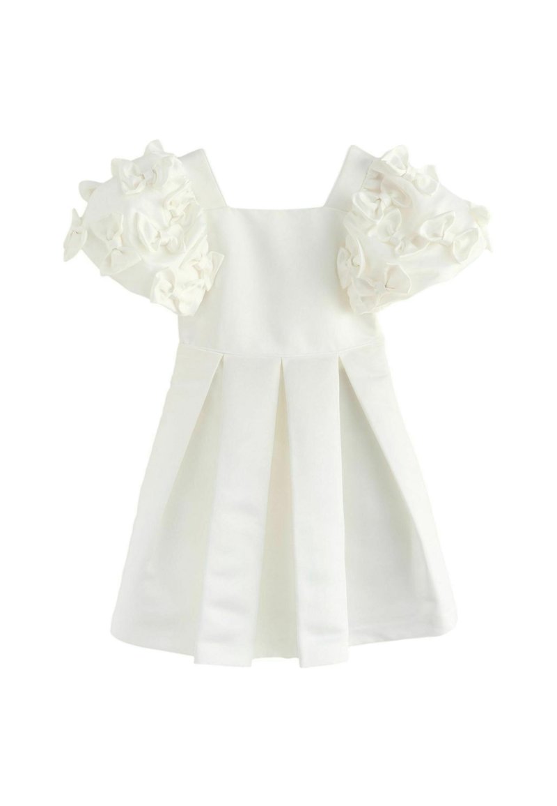 Valge kleit puhvärvidega, kaunistatud kangast volangidega, millel on kinnitatud bodice ja plisseeritud seelik, et luua struktureeritud siluett.