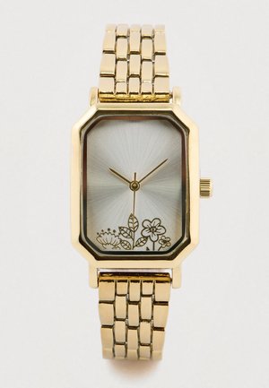 Montre en métal doré avec un cadran octogonal, un cadran argenté, une gravure florale et un bracelet à maillons métalliques plats. Aiguilles simples pour les heures et les minutes.