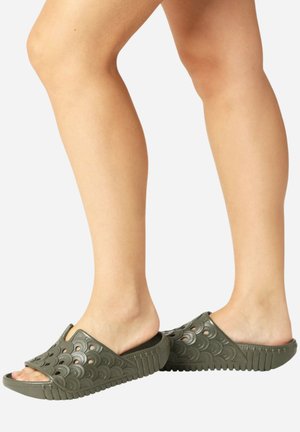 Groene rubberen slide-sandalen met uitgesneden golfpatronen, textuurzolen en open teenontwerp. Lichtgewicht en flexibele constructie.