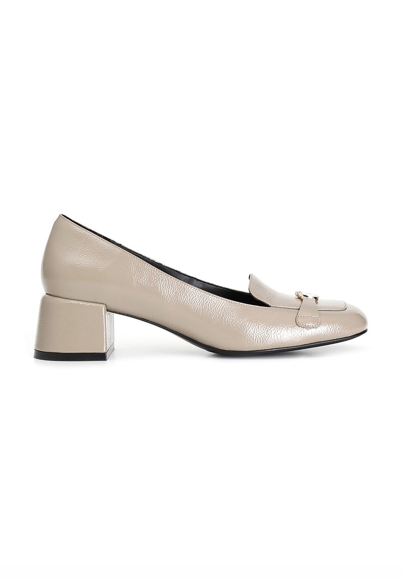 Zapatos de cuero beige con tacón cuadrado, puntera redondeada y un ribete decorativo en la parte frontal. Acabado texturizado que añade detalle.