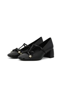 Scarpe con tacco in pelle nera, punta affusolata, con cinturini annodati decorativi e dettagli a forma di cuore dorati sul davanti. Design con tacco a blocco.
