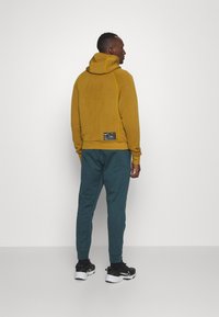 Nike Performance TAPER - Tracksuit bottoms - deep jungle