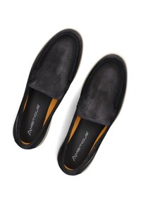 Zwarte suède instap schoenen met een lage profiel, voorzien van een gladde textuur, contrasterende oranje binnenvoering en een stevige rubberen zool.