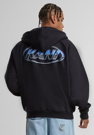 Felpa nera con cappuccio e un grande logo blu "KANI" sulla schiena. Dispone di un cappuccio con coulisse e polsini a costine, mostrando un design dal taglio morbido.