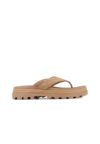 Tan slip-on sandal med ovandel i mocka, gummisula och texturerade detaljer. Har en minimalistisk design och en tåloop för säker passform.