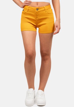 Geel denim shorts met een aansluitende snit, voorzien van een knoopsluiting aan de voorkant, riemlussen en twee zijzakken. Gestyled met witte sneakers.