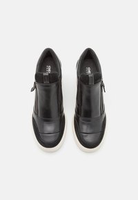 Schwarze Leder-Schlüpfschuhe mit kontrastierenden Wildlederakzenten, seitlichem Reißverschluss, gepolstertem Kragen und einer weißen Gummisohle.