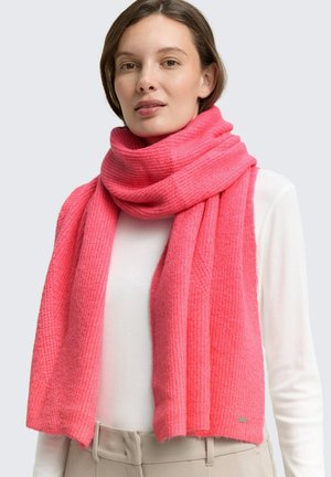 Écharpe tricotée rose avec une texture côtelée, drapée lâchement autour du cou, fabriquée dans un matériau doux, avec une petite étiquette logo à l'extrémité.