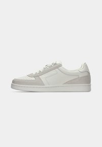 Witte en lichtgrijze sneakers met een bovenwerk van glad leer, suède accenten, geperforeerde neus, platte veters en een rubberen zool.