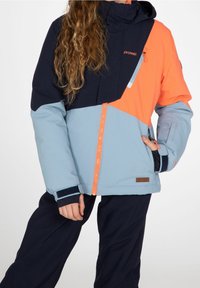 Blaue und orange Winterjacke mit Reißverschluss, Mehrfachpaneeldesign, elastischen Bündchen und Logodetail. Hergestellt aus isolierenden Materialien.