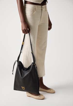 Zwarte leren hobo tas met een slouchy ontwerp, voorzien van een gouden logo accent en verstelbare banden. Gladde textuur; minimalistische vorm.