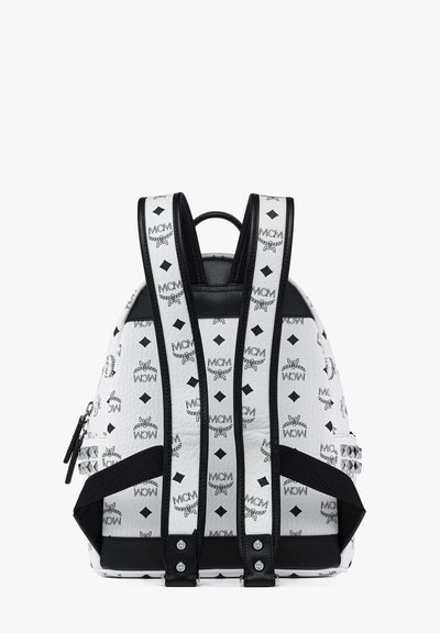 Weißer Leder-Rucksack mit schwarzem MCM-Logodruck, strukturierten Oberflächen, verstellbaren Riemen und silbernen Hardware-Akzenten.
