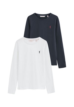 Dos camisetas de manga larga con cuello redondo, una blanca con un pequeño logo oscuro y una azul oscuro con un pequeño logo rojo en el pecho.