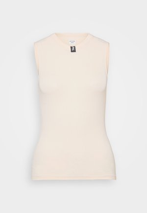 Ermeløs tettsittende topp i lys beige, laget av mykt, elastisk materiale. Rund hals med et merke synlig ved kragen. Glatt tekstur.