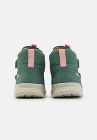 Zapatillas altas verdes con detalles en rosa, correas de Velcro, parte superior texturizada y suelas de goma de color claro. Vista trasera que muestra los detalles del diseño.