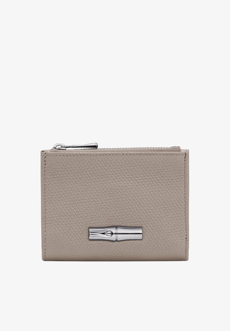 Beige leather wallet with a textured finish, silver hardware, and a zip closure. Features a prominent metallic accent on the front.