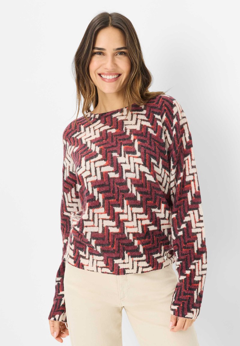 Maglione lavorato a maglia con motivo a zigzag in bordeaux, crema e nero. Collo rotondo e maniche lunghe con vestibilità comoda.