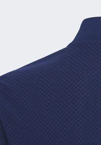 Polo shirt blu navy con un motivo a diamante testurizzato, colletto e polsini a costine, e una finitura del tessuto liscia.