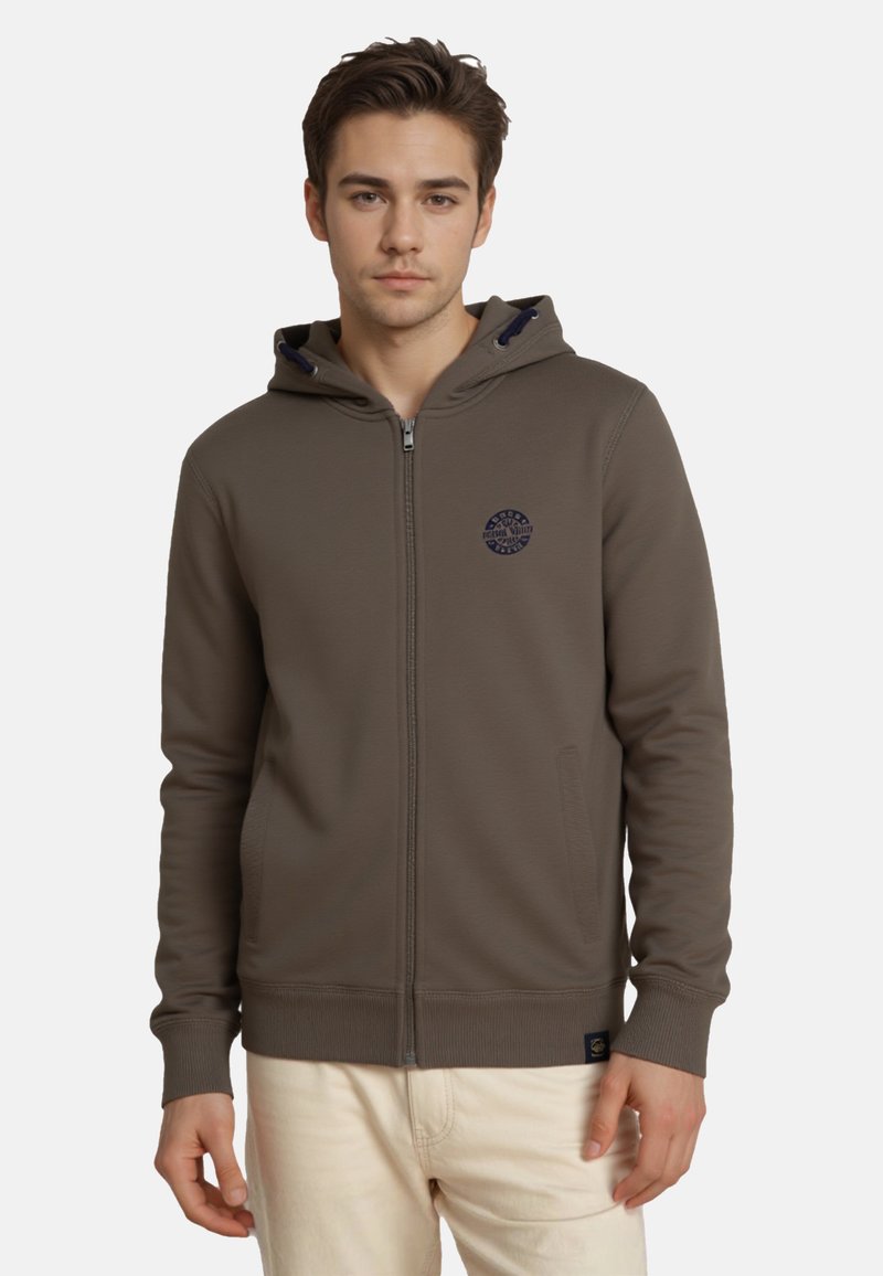Sudadera con capucha y cremallera en verde olivo, cuenta con un parche de logotipo en navy en el pecho, bolsillos laterales y puños y dobladillo acanalados. Textura de tela suave.