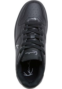 Schwarze Ledersneaker mit perforiertem Vorderfuß, flachen schwarzen Schnürsenkeln und weißem Logo auf der Zunge. Glatte Textur und runde Form.
