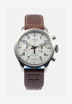 Timex Waterbury hronogrāfa pulkstenis ar sudraba ciparnīcu, brūnu ādas siksniņu, lieliem cipariem un divām apakšciparnīcām. 100m ūdensizturīgs.