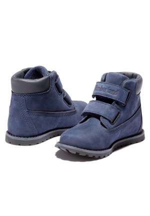 Para niebieskich dziecięcych butów za kostkę z podwójnymi paskami na rzepy i czarnymi, wyściełanymi kołnierzami, lekkimi podeszwami z bieżnikiem, logo Timberland na paskach.