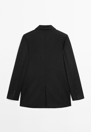 Blazer noir ajusté avec un col cranté, des manches longues et des accents de boutons. Texture lisse avec une fente au dos et une silhouette structurée.
