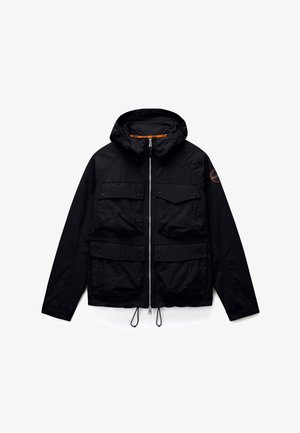 Chaqueta negra con capucha, cremallera frontal, cuatro bolsillos con solapa, cordones ajustables en el dobladillo y parche circular con logo en la manga izquierda.