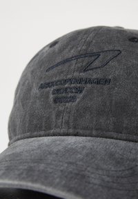 Gray fabric cap with stitched blue logo and text "AFRKOPENHAGEN DK.COM" near the visor, featuring a curved brim and textured surface.