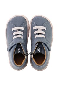 Zapatos de ante azul con cordones elásticos blancos, una correa de velcro y suelas de goma texturizadas. El interior tiene un forro en tono beige.