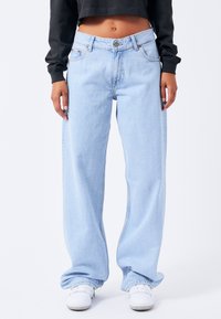 Light blue wide-leg jeans made of denim with a mid-rise waist, featuring copper rivets and a classic five-pocket design.