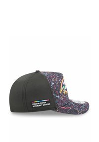 Casquette avec des panneaux perforés noirs et un motif éclaboussé coloré sur la visière. Présente un patch de logo "Crucial Catch".