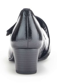 Talons en cuir verni noir avec un embout légèrement arrondi et une sangle sur le coup de pied. Talon carré court et texture lisse.