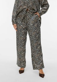 Long, loose-fitting pants in a wave pattern, featuring shades of navy, beige, and cream. Made of soft, lightweight fabric with an elastic waistband.