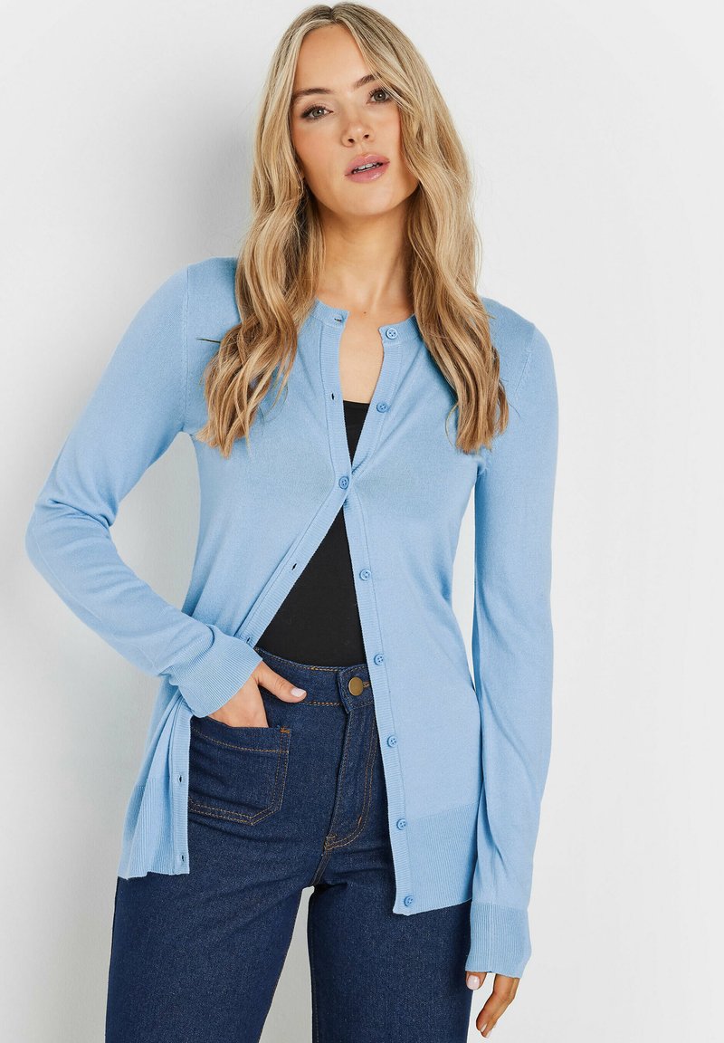 Lichtblauwe cardigan van gebreide stof, met lange mouwen, een knoopsluiting aan de voorkant en een aansluitende pasvorm, gecombineerd met donkere jeans.