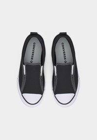 Para czarno-białych tenisówek na wsuwanie marki Converse z białymi gumowymi czubkami i widocznym przeszyciem na jednolitym tle.