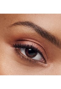 Lähikuva silmästä, jossa on pronssinen luomiväri, määritellyt ripset ja tumma iiris. Yläluomessa on hienovarainen tekstuuri ja luonnollinen kulmakarvamuoto yllä.