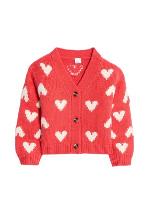 Koralowy różowy sweter na drutach z białymi wzorami serc, dekolt w serek, długie rękawy, ściągacze przy mankietach oraz trzy brązowe guziki z przodu.