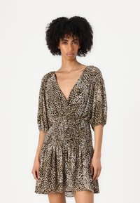 Abito in stampa leopardata realizzato in tessuto leggero, con scollatura a V profonda, maniche a palloncino corte e vita arricciata, accompagnato da una gonna svasata.