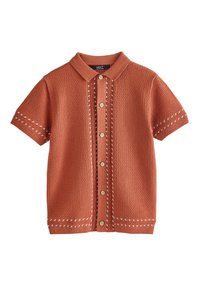 Polo a maniche corte di colore ruggine, con motivo a rilievo, bottoni sul davanti e cuciture a contrasto in bianco lungo le giunture.