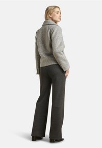 Gray wool blend jacket with a collar, textured pattern, and buttons. Paired with dark gray wide-leg pants and block-heeled shoes.