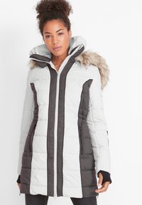 Cappotto invernale imbottito in grigio chiaro e grigio scuro con cappuccio foderato in pelliccia, maniche lunghe e tasche con cerniera. Presenta una texture trapuntata.