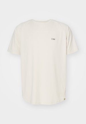 Kremowa koszulka z okrągłym dekoltem i krótkimi rękawami. Posiada małe szare logo na lewej piersi. Miękka tekstura, luźny krój.