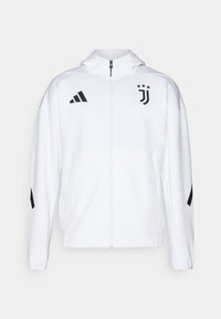 Hvid sportsjakke med lynlås foran, hætte og sorte detaljer, med Adidas-striber og Juventus-logo på brystet.