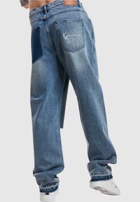 Volné modré džíny z denimu s patchworkovým designem, bledým vzhledem, vysokým pasem a vyšívaným logem na zadní kapse.
