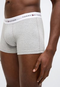 Šedé bavlněné boxerky s bílým pasem s logem "TOMMY HILFIGER". Přiléhavý střih, hladká textura a krátká délka nohaviček.