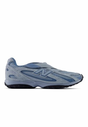 Светлосин спортен обувка New Balance с горна част от мрежа и велур, черна подметка и лого отстрани, показана от външната страна.